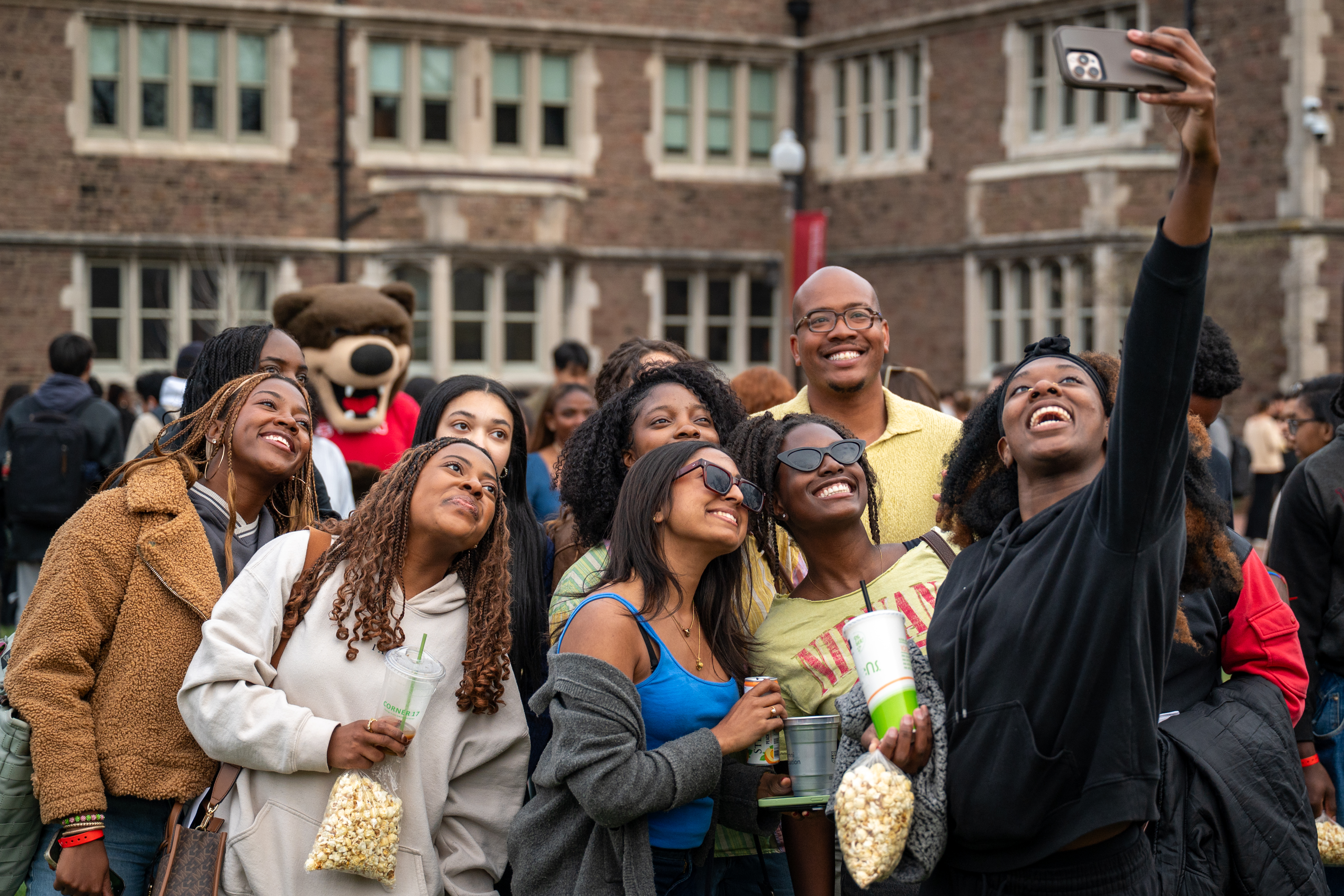 Students at the Class of 2026 Toast taking a selfie with a camera.